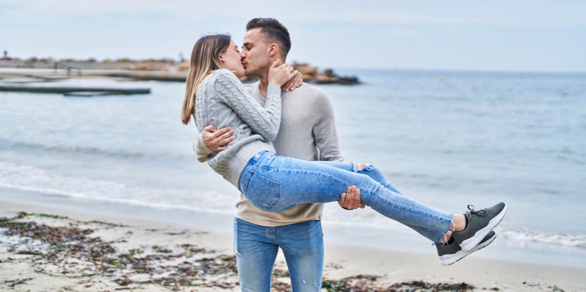 man holding woman at the beach