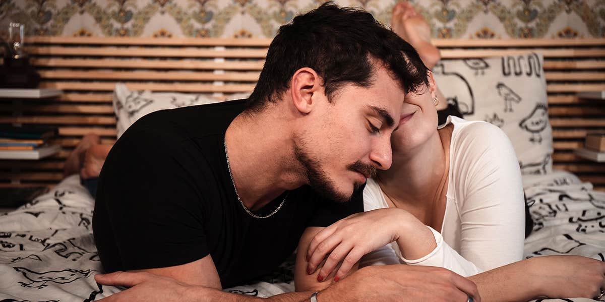 man and woman cuddling in bed