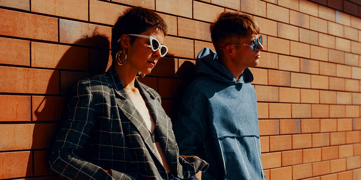 couple leaning against brick wall