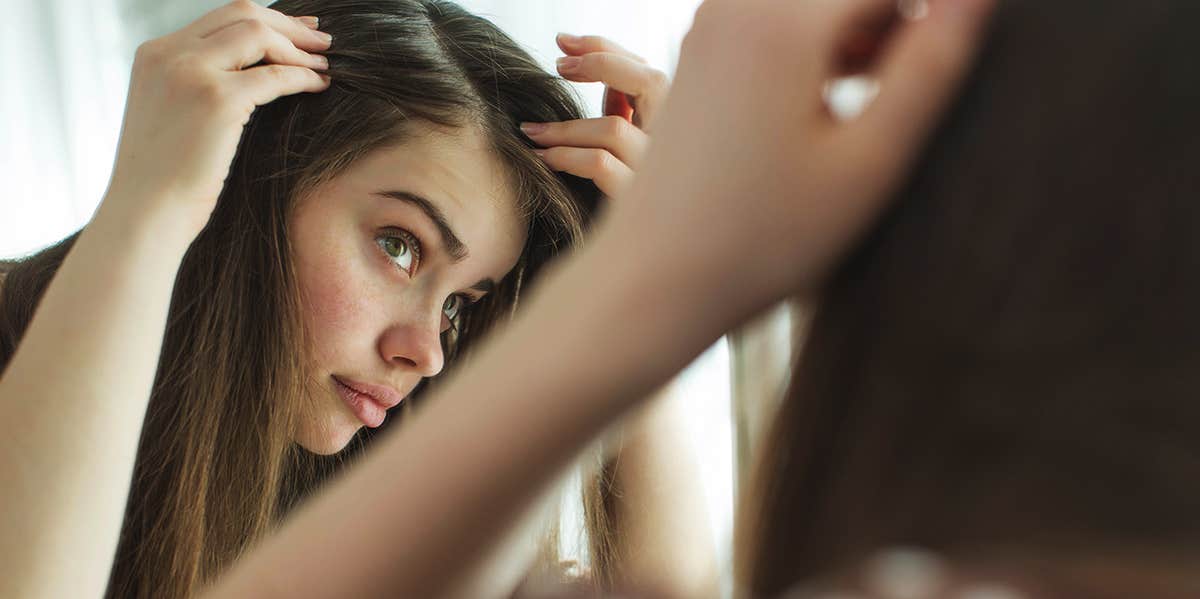 woman checking hair in the mirror