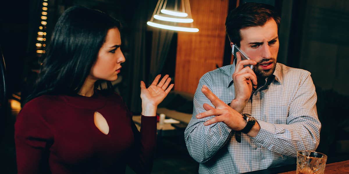 man ignoring woman on date