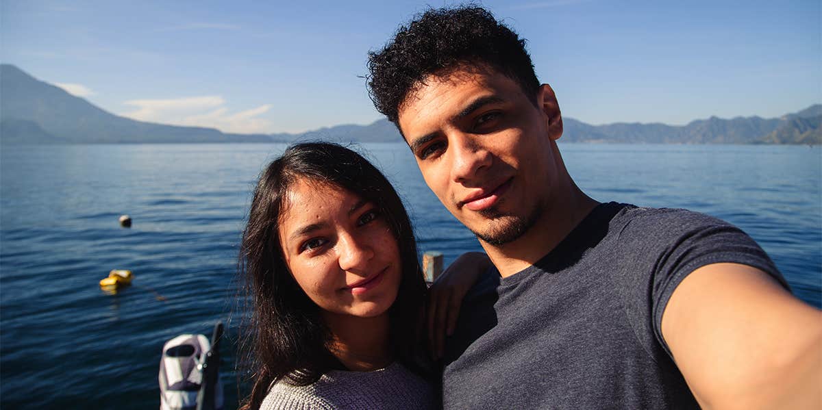 couple taking selfie by water