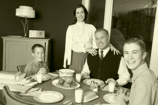 Retro parents and kids at family dinner table