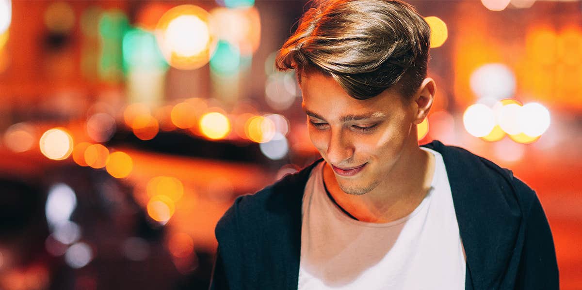 young man smiling walking at night