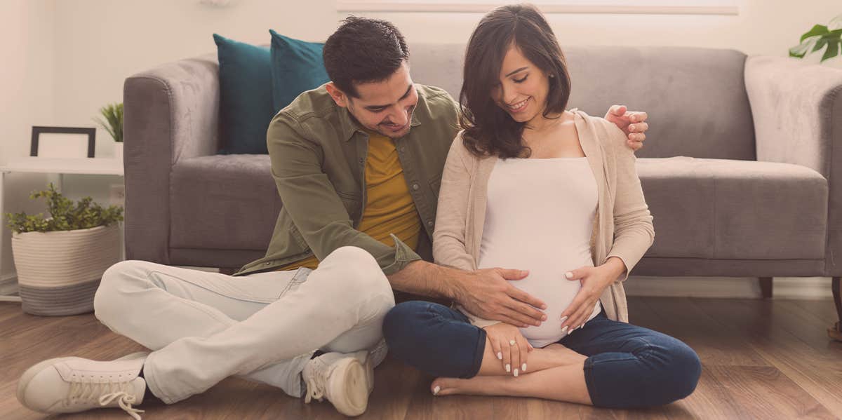 man touching the stomach of a pregnant woman