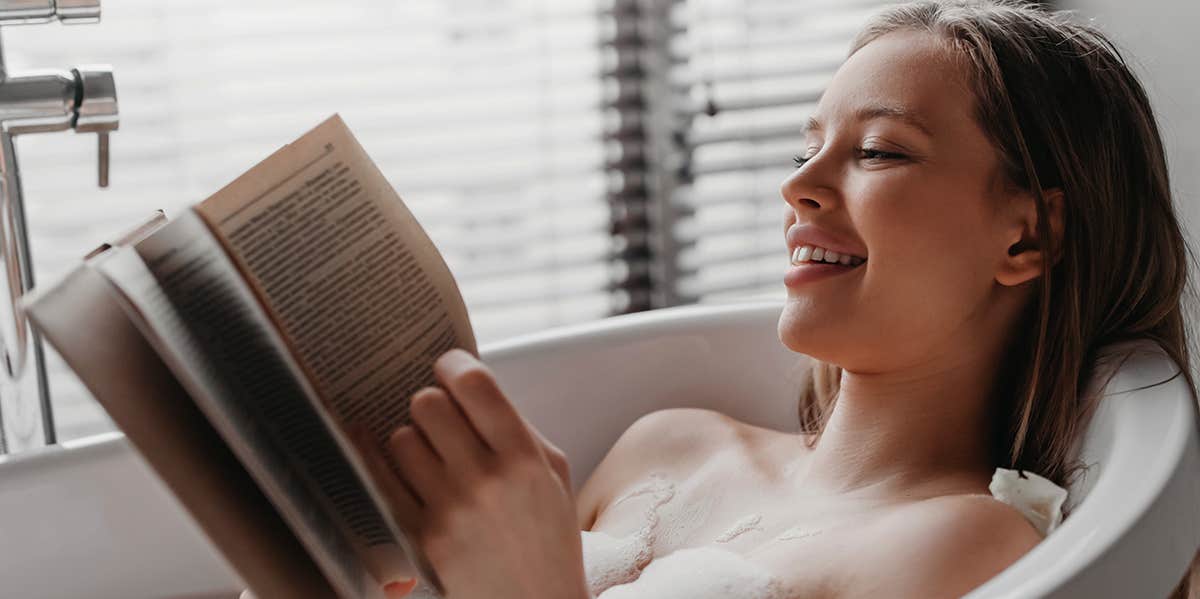 girl relaxing reading in bath
