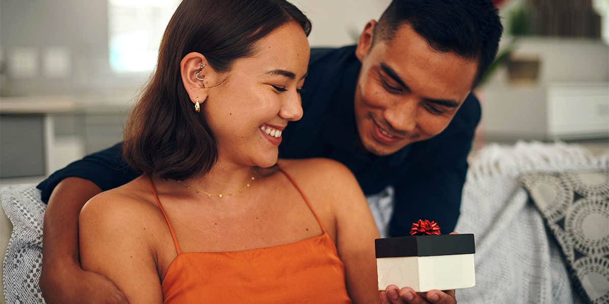 20 Thoughtful Things to Give to a Woman Whose Love Language Is gift man giving girlfriend a present