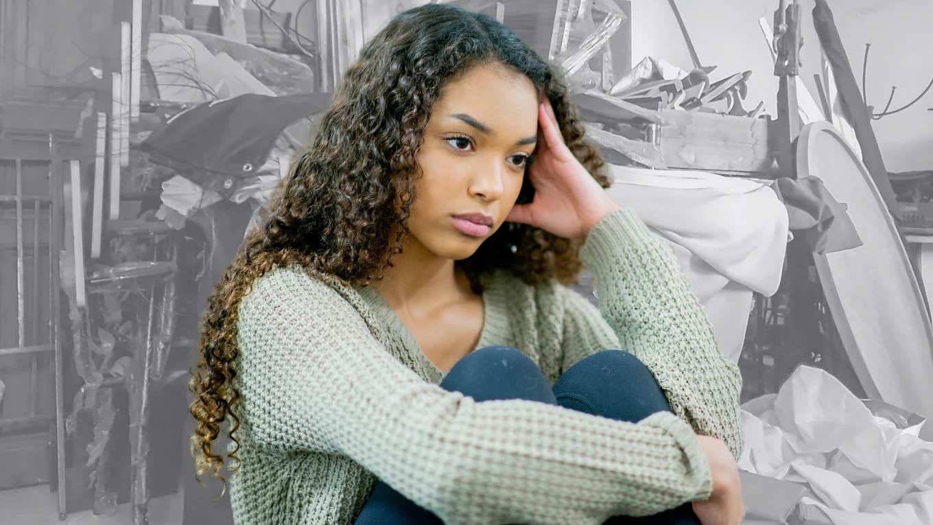 Teenage girl in a messy house looking upset.