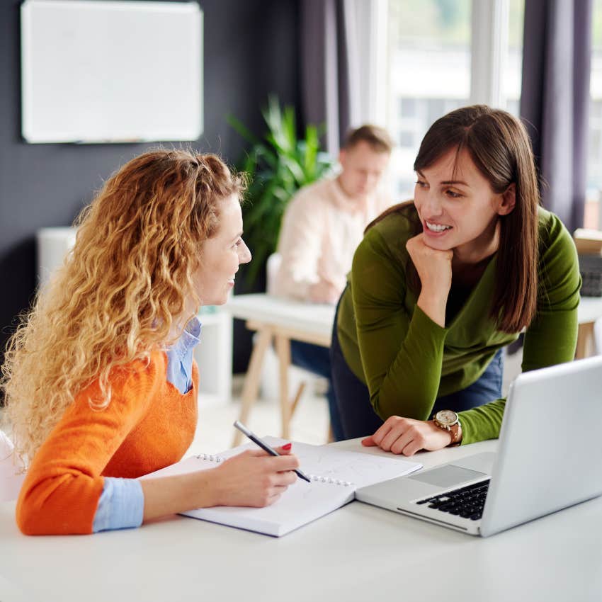 two women colleagues chatting in an office