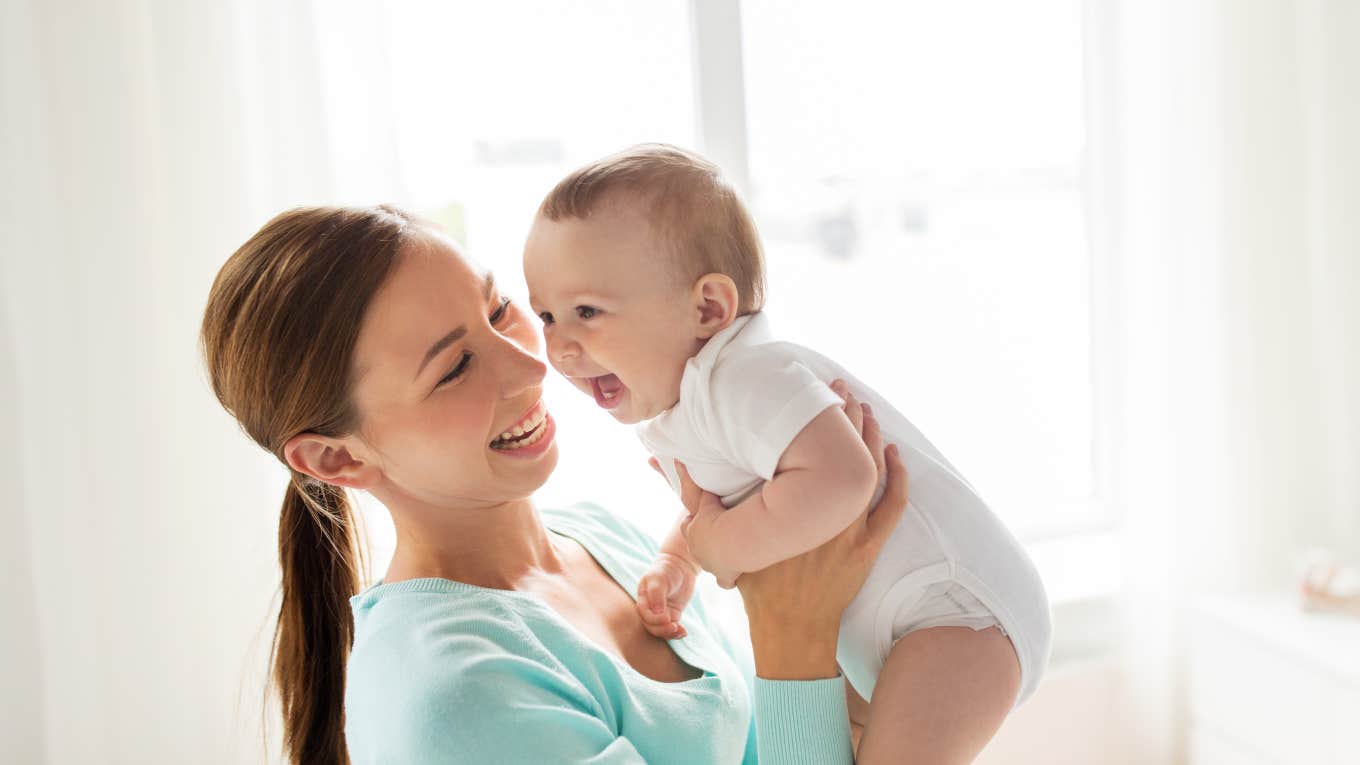 mom holding smiling baby