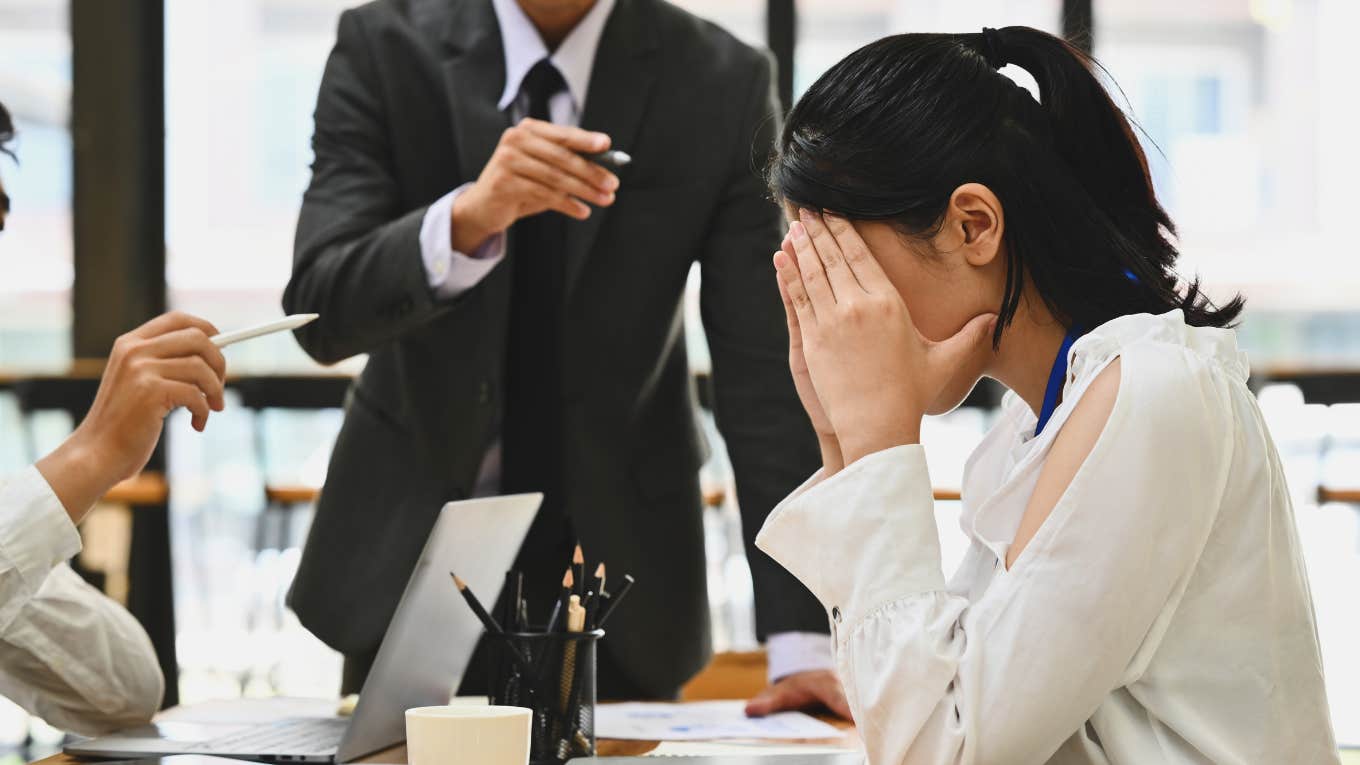 Worker looking frustrated in a room with her boss. 