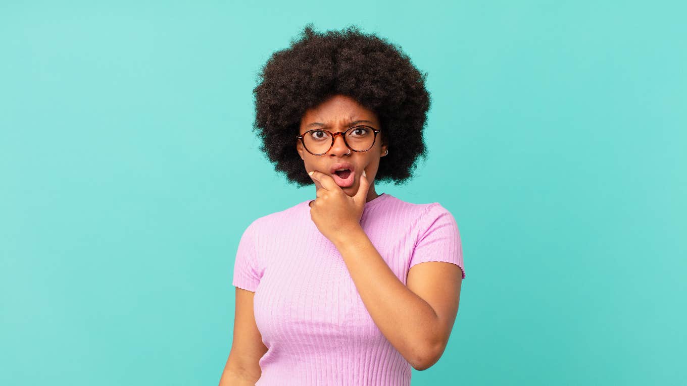woman looking shocked while holding face