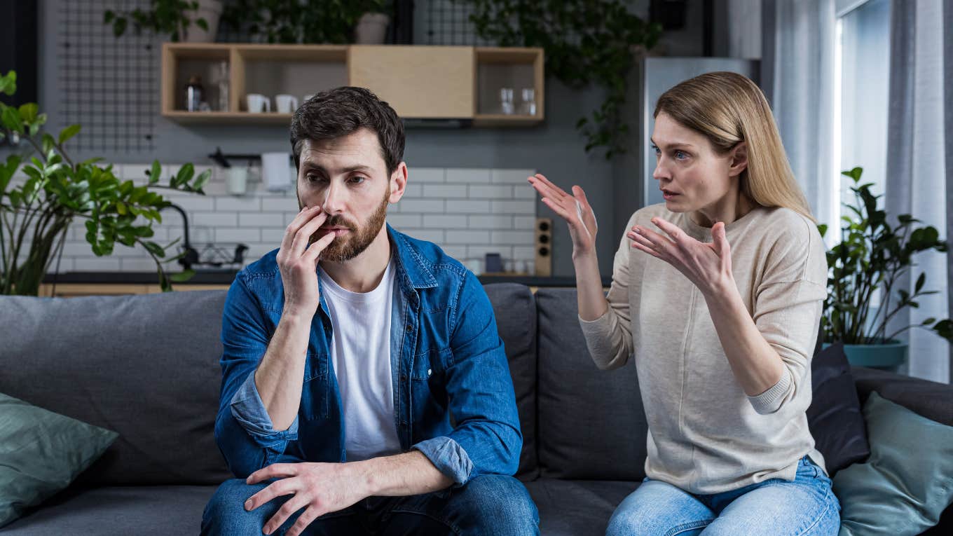 man and woman sitting on sofa at home arguing