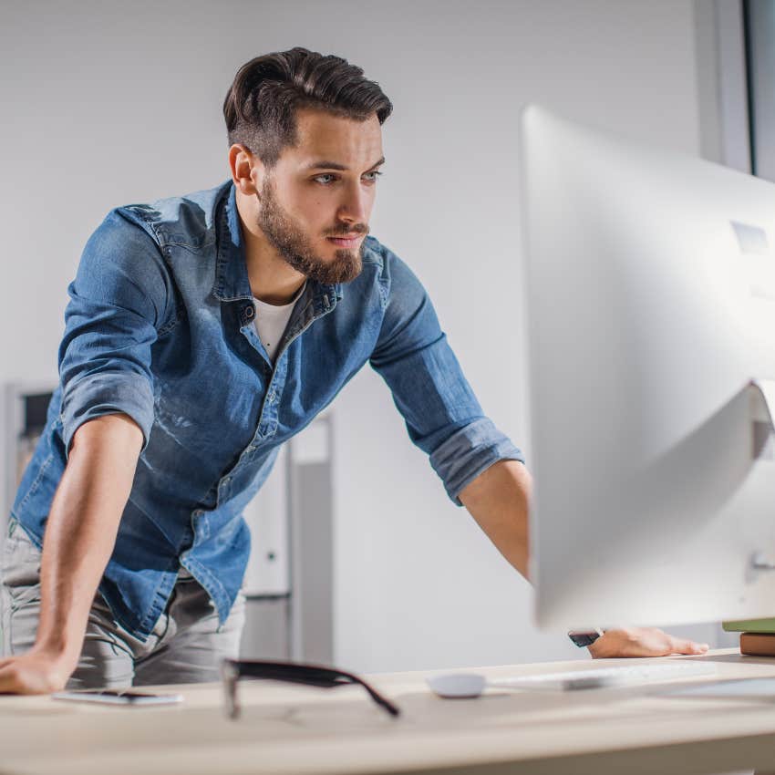 handsome male employee standing at desk