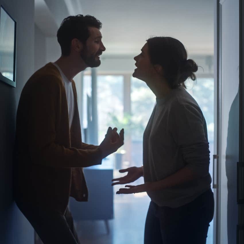 couple arguing with each other in dark hallway at home