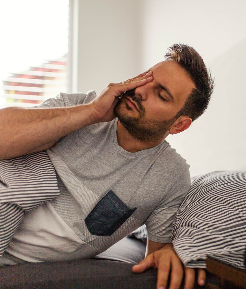 man rubbing his face trying to wake up