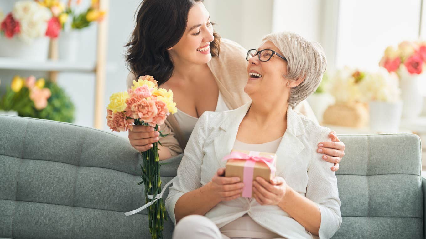 adult daughter and mother with gift box and flowers