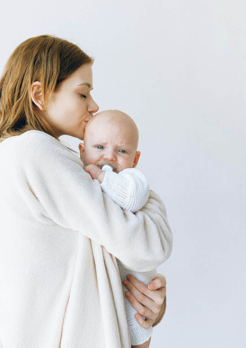 mom kissing baby on the top of the head