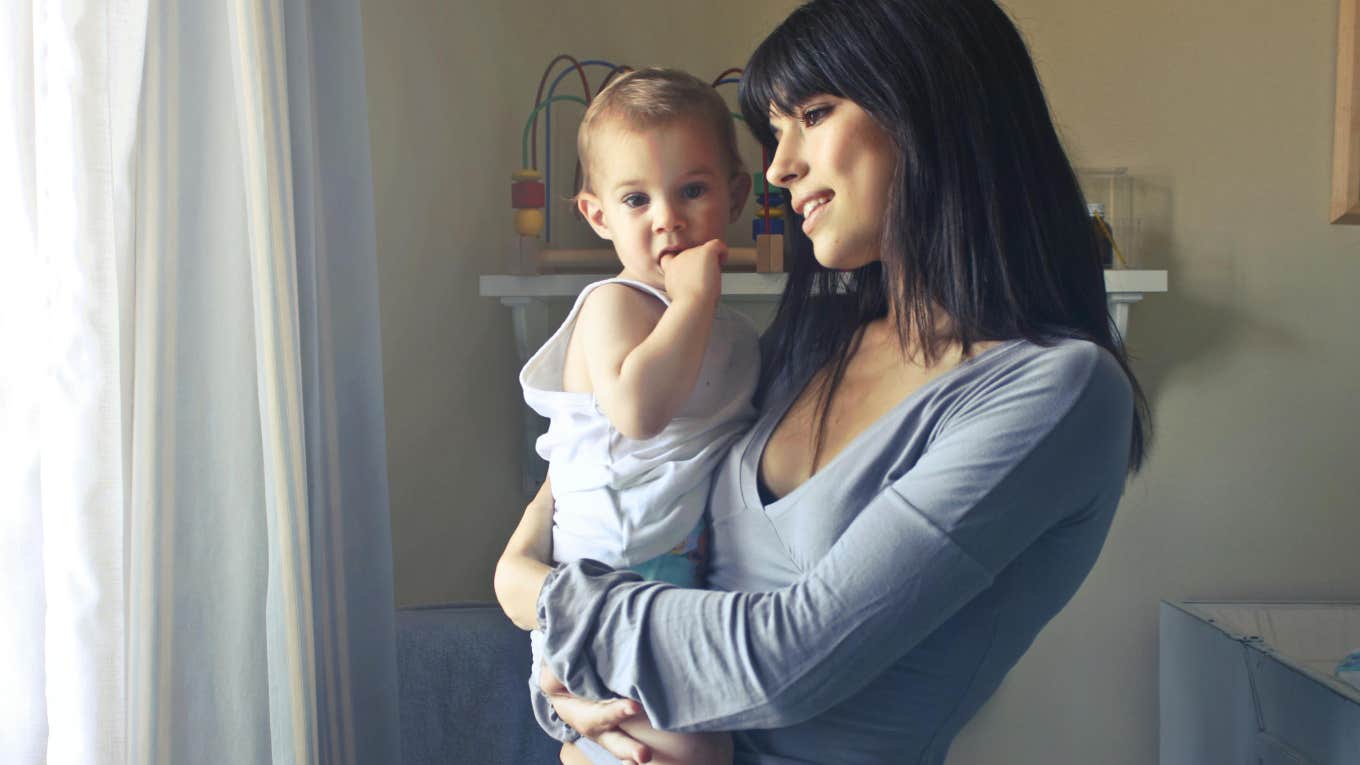 Mom Explains Why Paying $5,400 A Month For Full-time Daycare And An Au Pair For Her Kids Is Necessary nanny holding baby