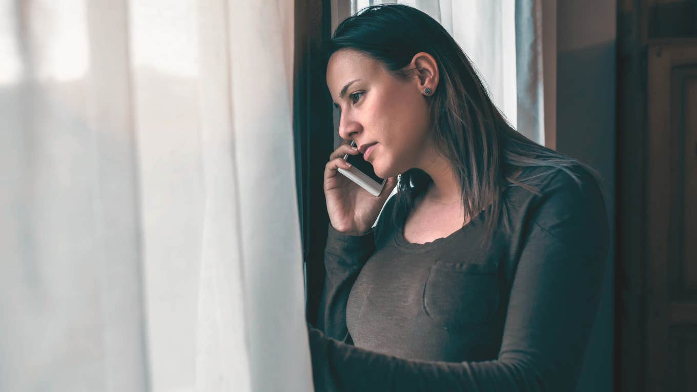 Teacher looking out her windows at home. 