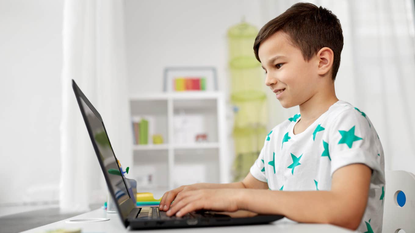 Fourth grade student working on his laptop. 