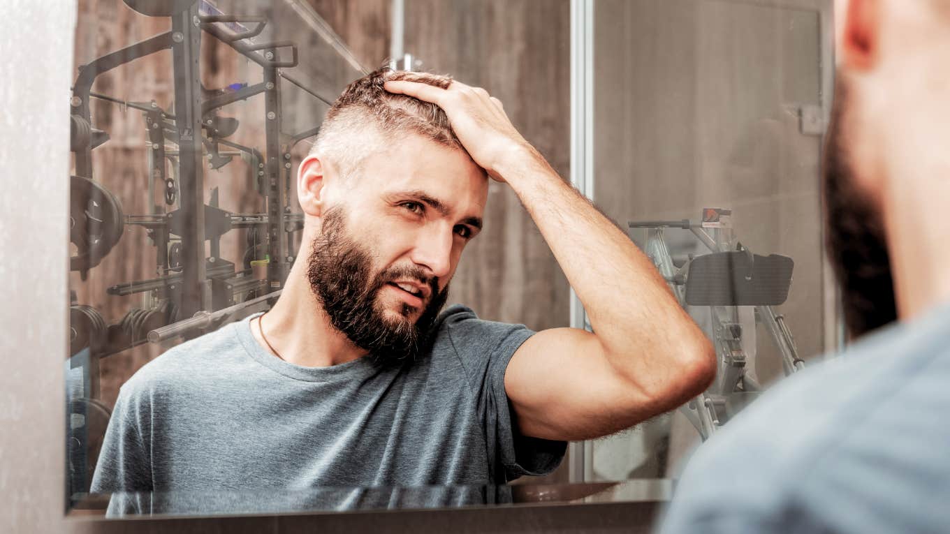 Sign husband is cheating, running hands through hair in mirror at the gym