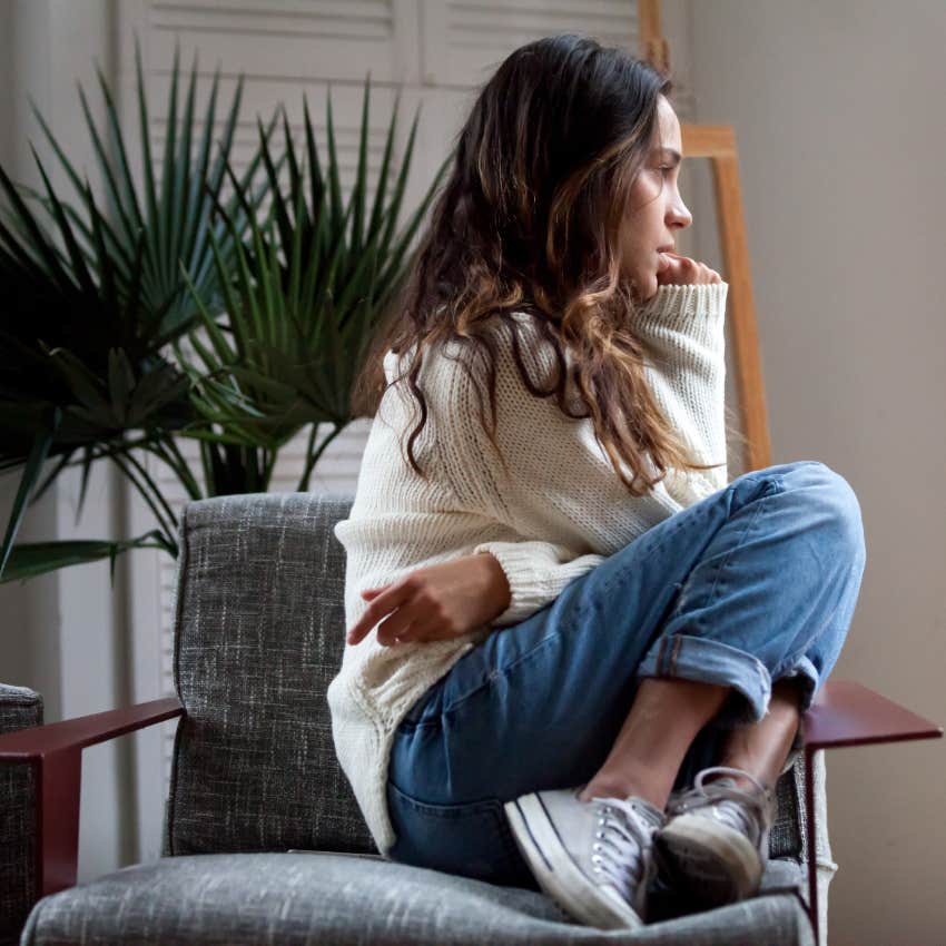 teen girl sits on chair feeling depressed