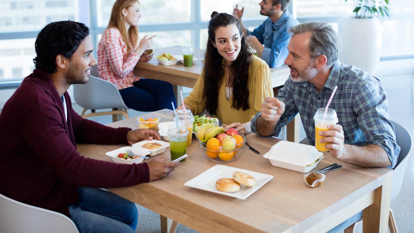 Co-workers eating lunch together at work