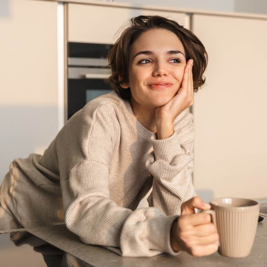 Woman smiling while drinking tea. 
