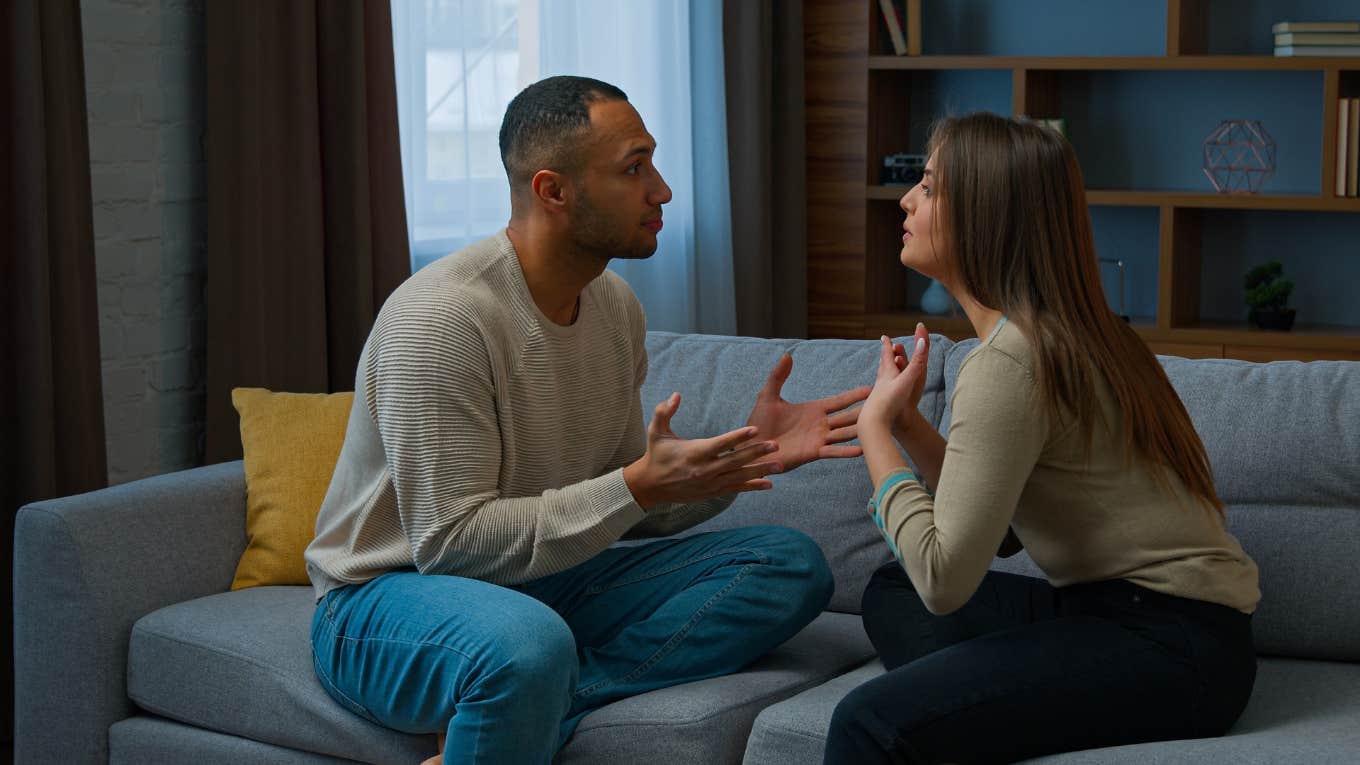 couple arguing while sitting on couch in house