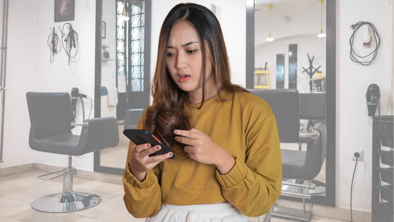 Hair stylist looking surprised reading something on her phone. 