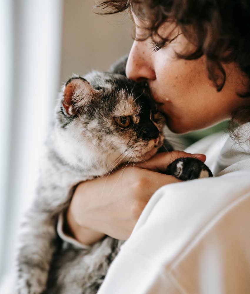 woman kissing cat