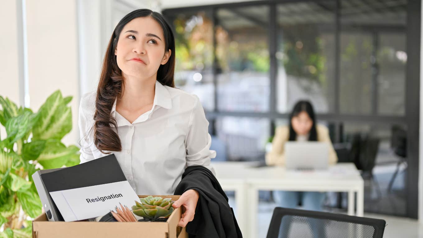 woman exiting office with box of things after quitting