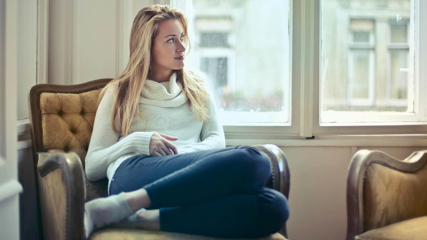 The 7 Types Of Rest You Need To Actually Feel Fully Refreshed woman sitting in a chair smiling