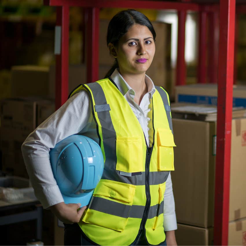 female factory worker holding hardhat 