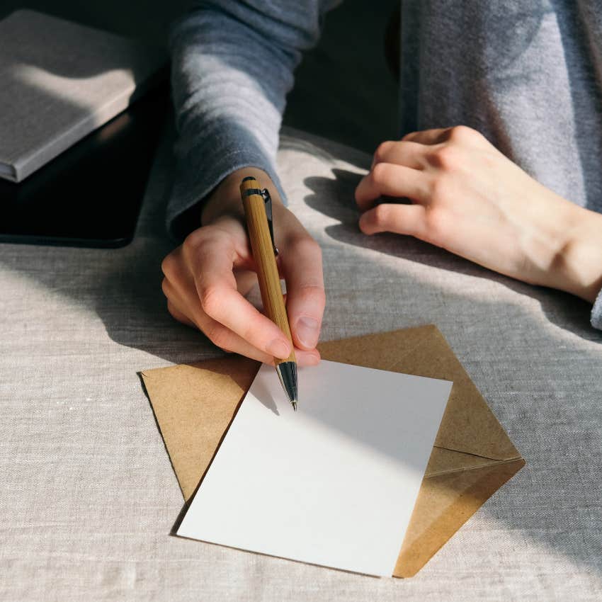 Woman writing wedding invitation card
