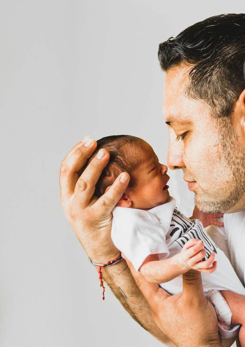dad holding newborn baby in his hands