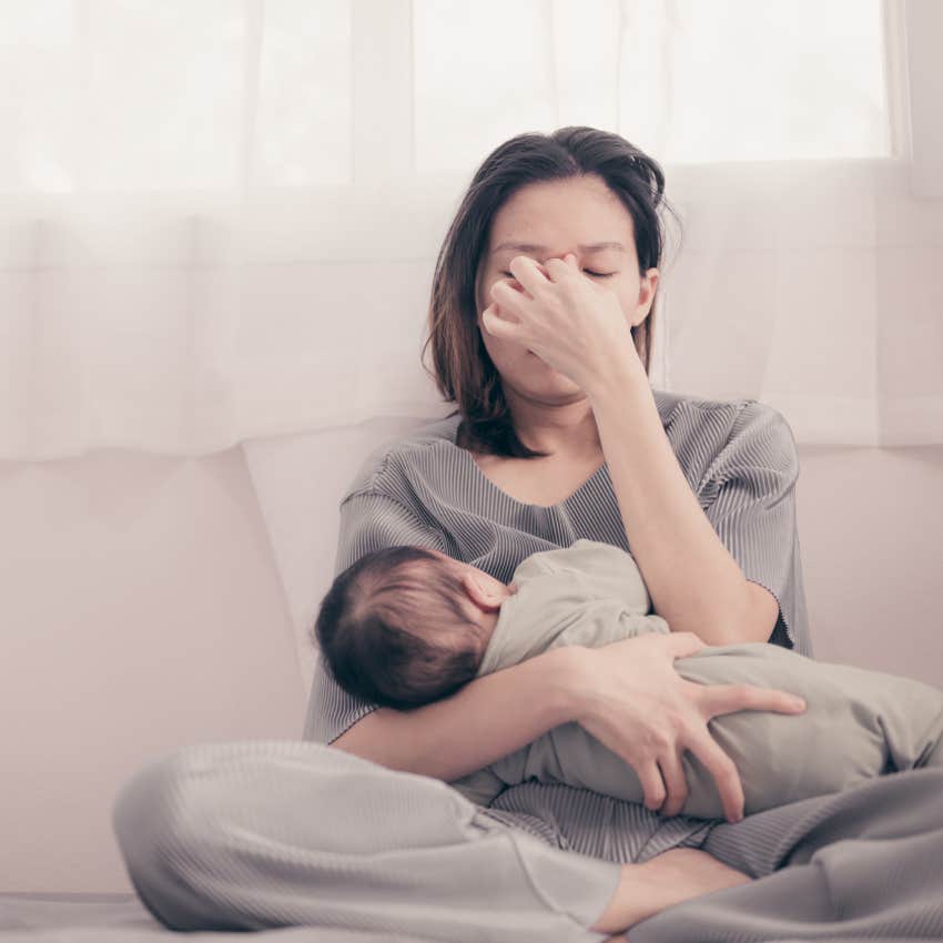 tired mother holding sleeping baby