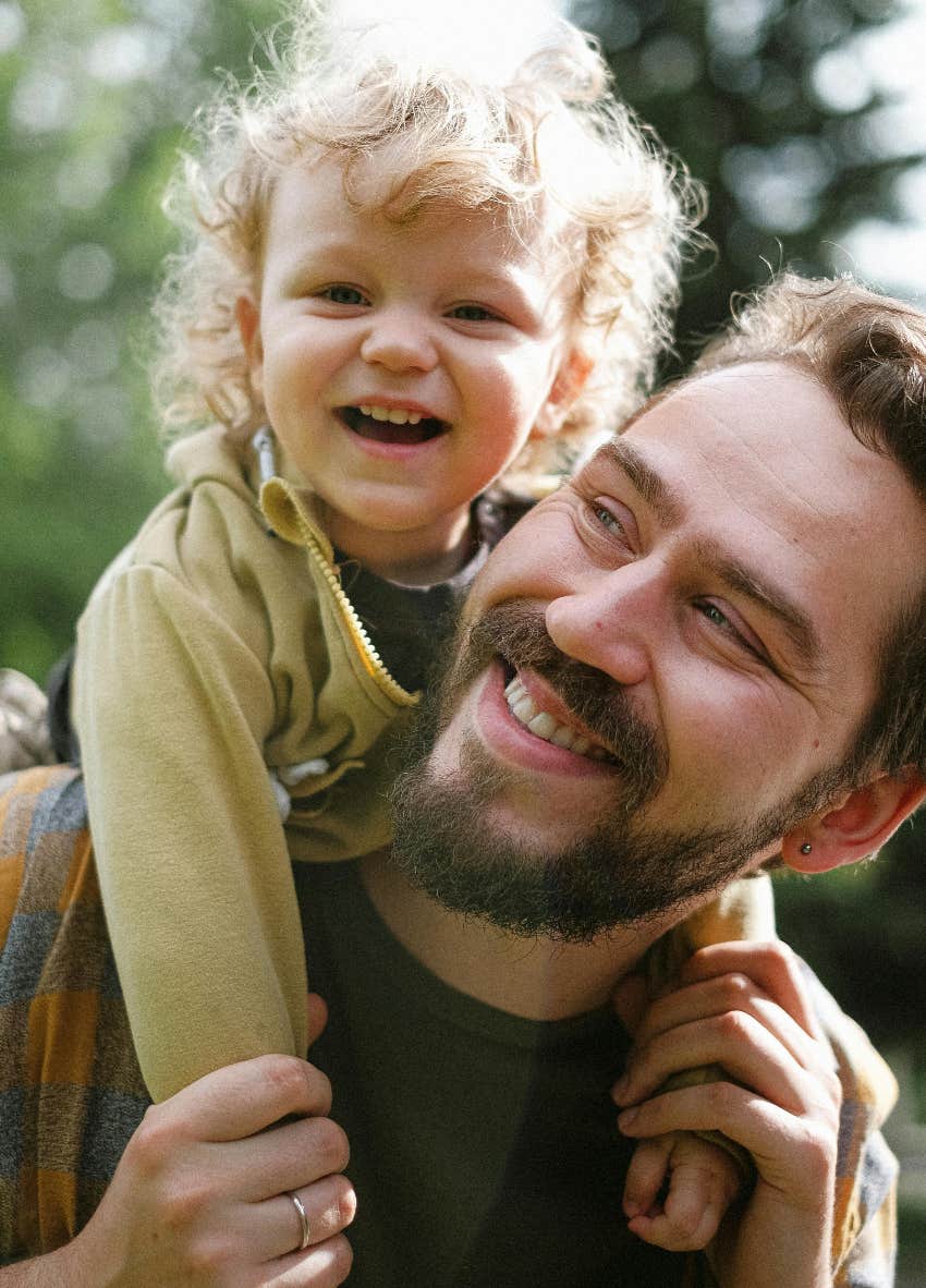 happy dad holding smiling toddler