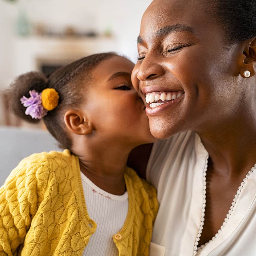 Young daughter kissing mom on the cheek