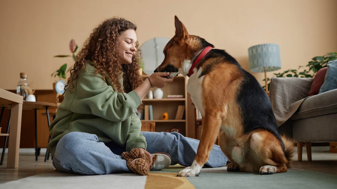 Dog Trainer Reveals The Fun Way to Stop Your Dog From Barking At Noises Outside Woman training her dog not to bark with treats