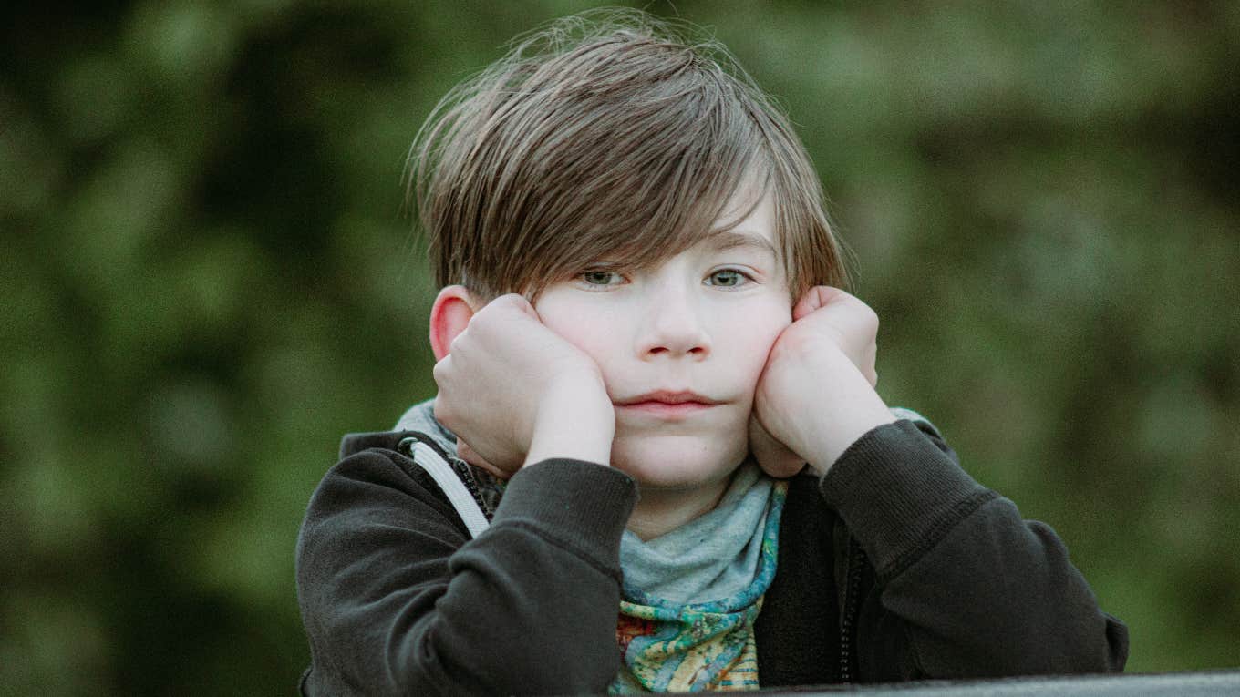 Five Signs Of Childhood Emotional Neglect little boy looking sad while holding head in hands