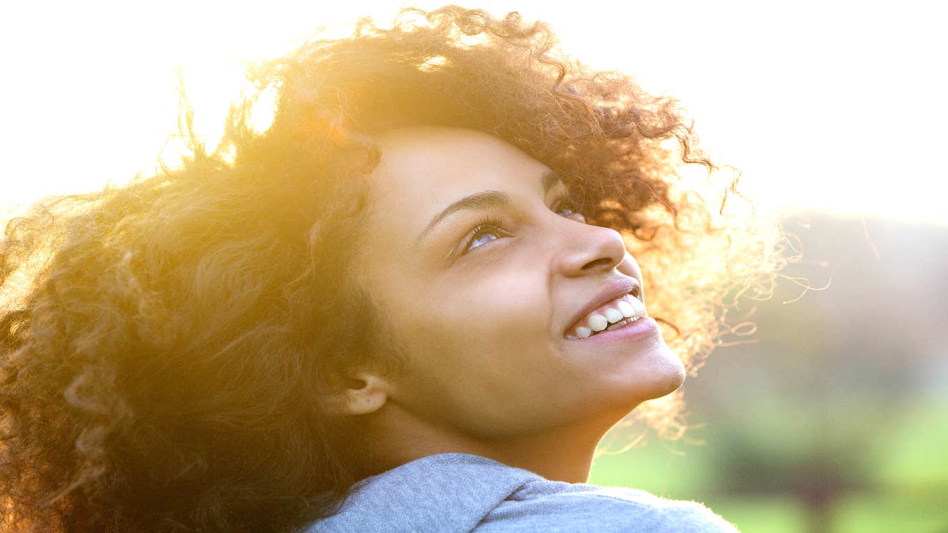 woman looking up at sky while smiling