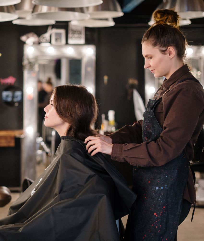 hairstylist putting cape on client