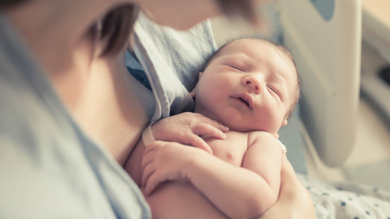 Husband Demands Wife Pay Hospital Bill For Birth Of Their Child mom holding newborn baby in hospital bed