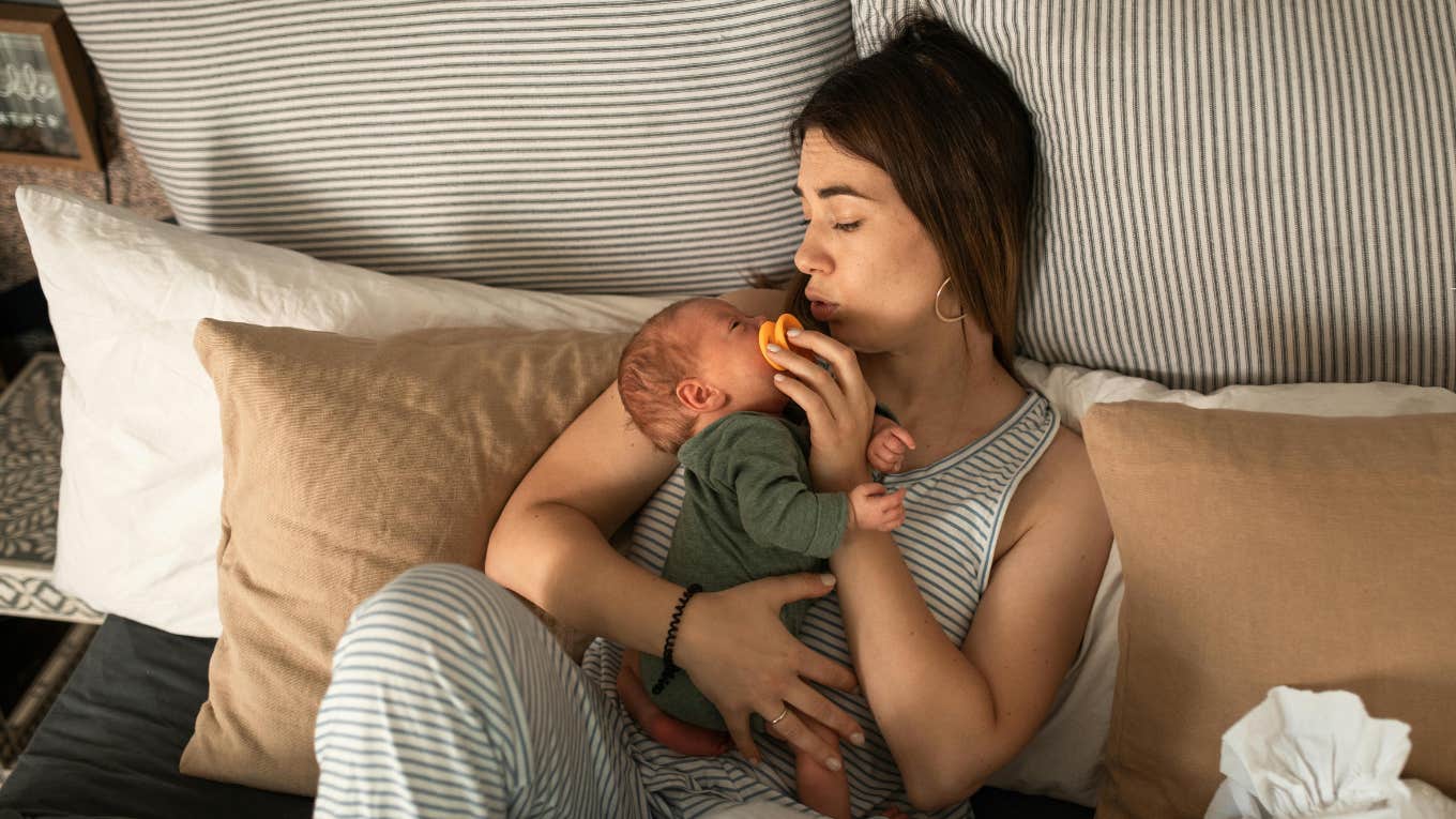 Husband Follows Wife Into Shower A Week After She Gave Birth, Calls Her Fat & Says Her Stomach Shouldn’t Poke Out new mom lying on bed with baby