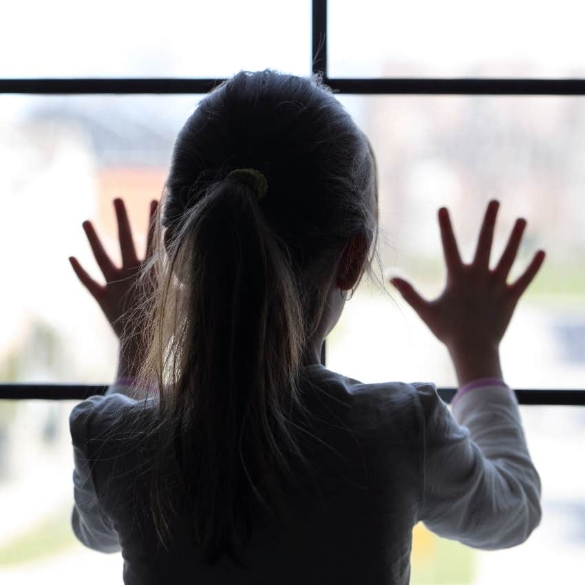 Little girl waiting by the window for her dad to pick her up