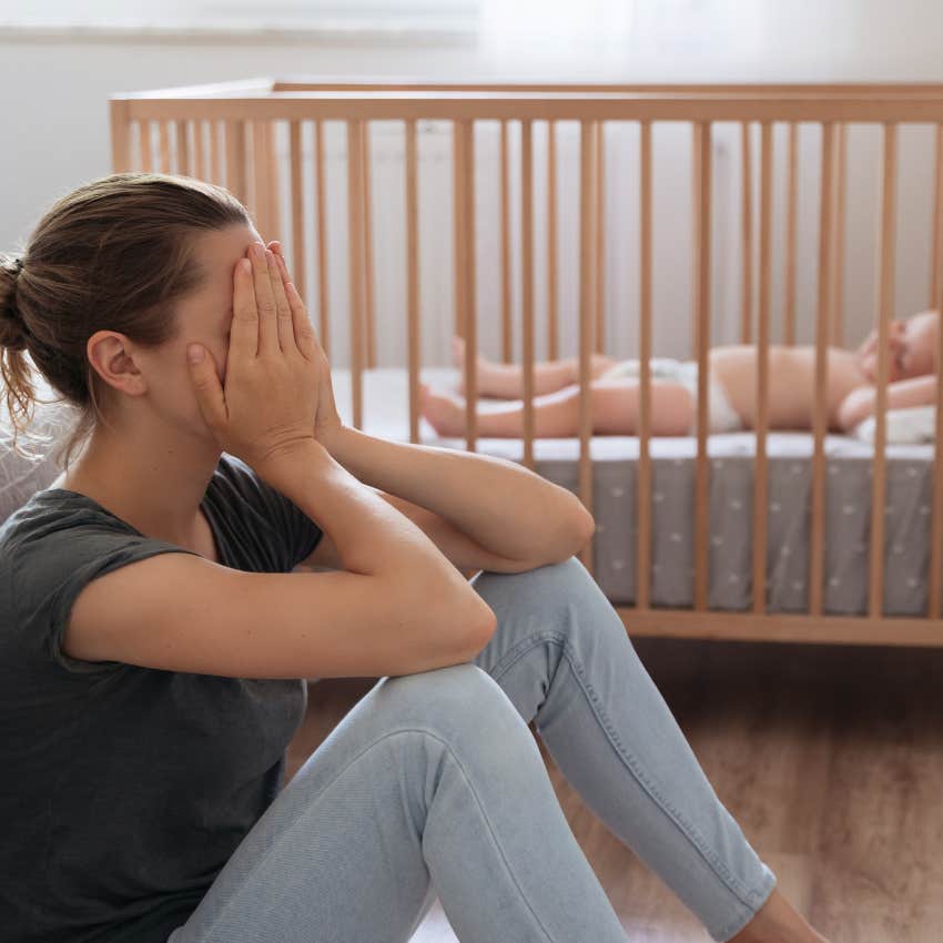 tired mom with baby in crib 