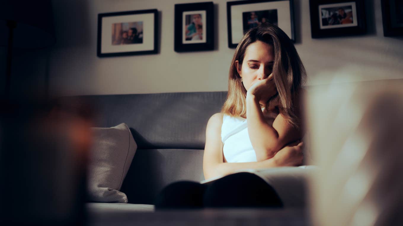 sad woman sitting on couch looking down