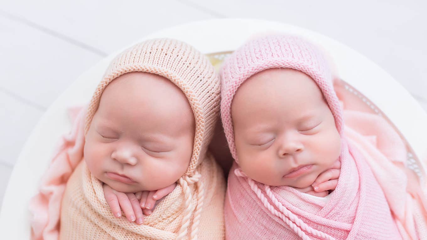 Mom Refuses To Tell Family Which Of Her Babies Is Adopted So They Don't Treat Them Differently two newborn baby girls swaddled next to each other
